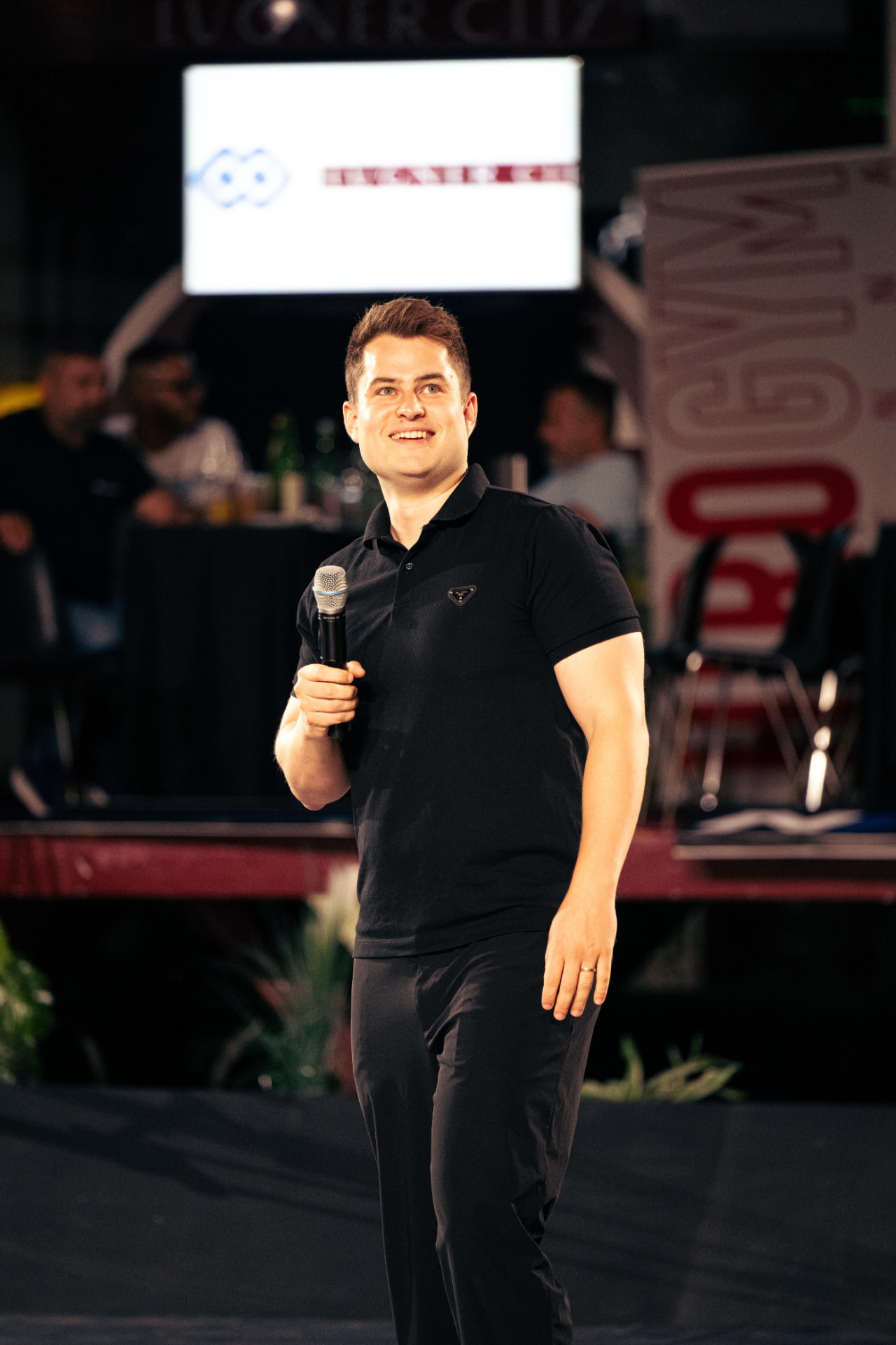 Luca van der Goes moderiert auf einer Event-Bühne